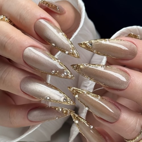A Set of 10 Handmade Press-On Nails That Can Be Reused Multiple Times, Featuring Unique Stiletto Shapes in Champagne And Golden French Styles, Adorned with Luxurious Crystals And Shiny Pearls.