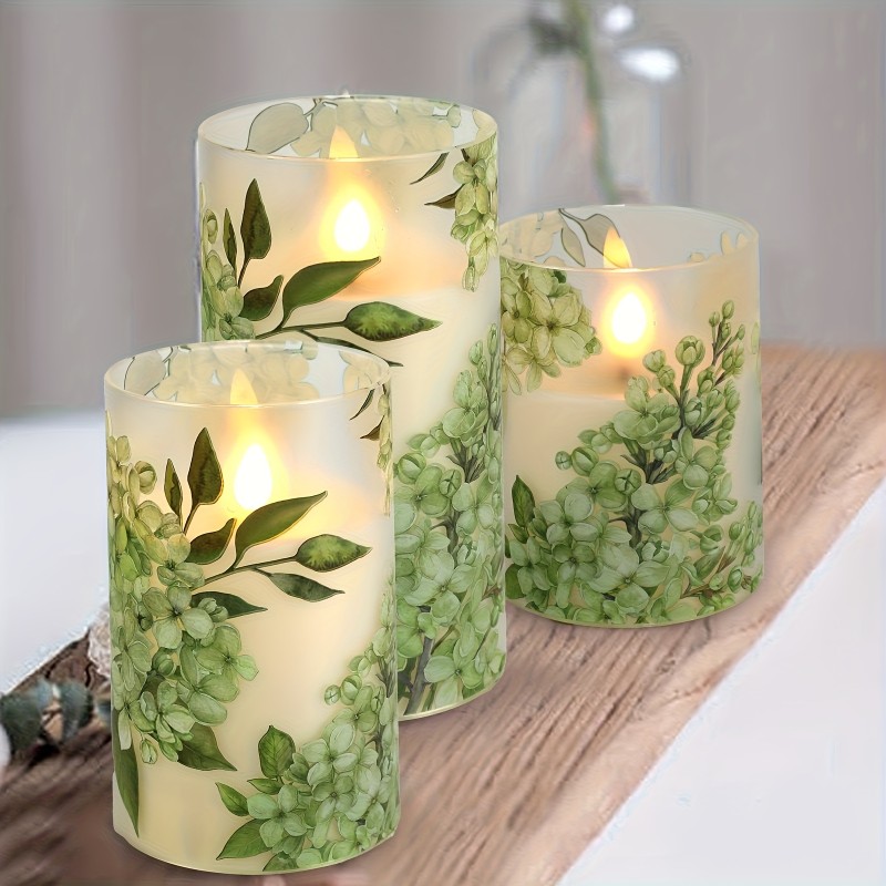 A set of 3 flameless candles, flickering LED pillar candles, with a 10-button remote control. They feature a green floral theme, are suitable for spring and summer, and can be used on the dining tables at wedding venues