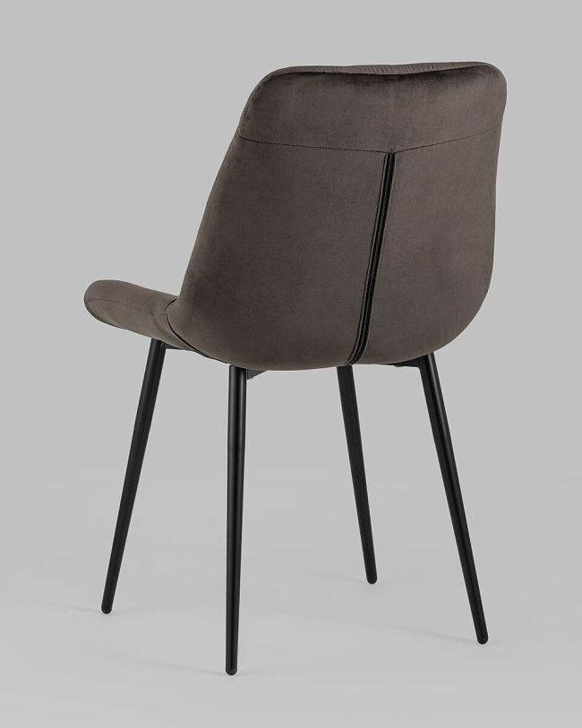Coffee color velvet tufted dining chair with a curved back and sleek metal legs